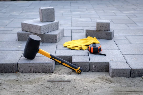 The master in yellow gloves lays paving stones — Stock Photo, Image