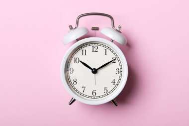 Pembe arka planda beyaz klasik alarm saati