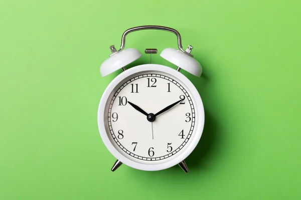 White vintage alarm clock on green background — Stock Photo, Image