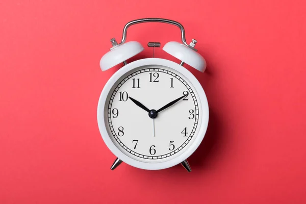 Relógio de alarme vintage branco no fundo vermelho — Fotografia de Stock