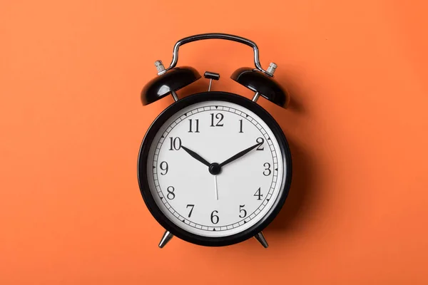 Relógio de alarme vintage preto no fundo laranja — Fotografia de Stock
