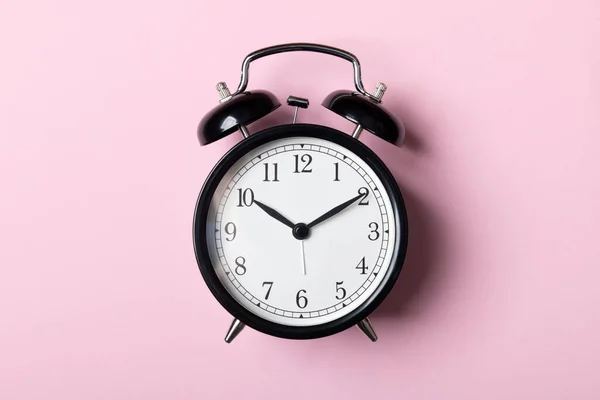 Reloj despertador vintage negro sobre fondo rosa —  Fotos de Stock