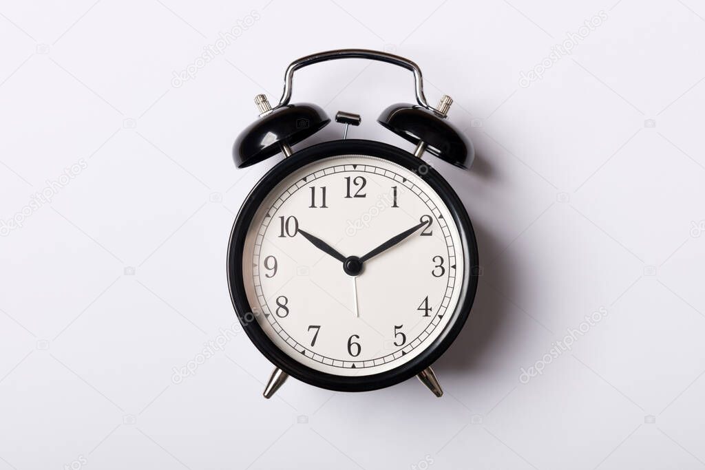 Black vintage alarm clock on white background