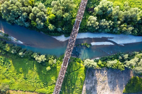 Puente ferroviario de acero sobre un pequeño río —  Fotos de Stock