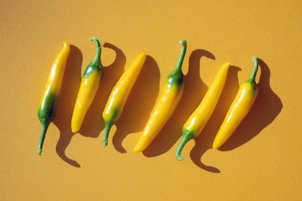 Gele hete paprika 's op gele achtergrond — Stockfoto