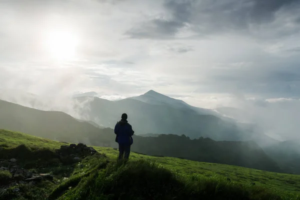 Menschensilhouette auf bewölkten Bergen — Stockfoto