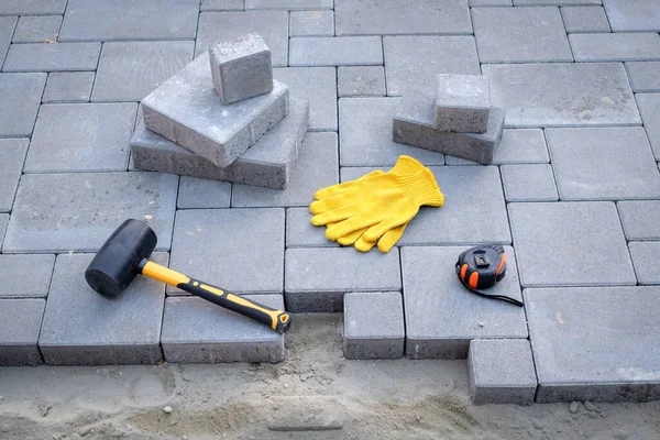 Il padrone in guanti gialli posa pietre di pavimentazione — Foto Stock