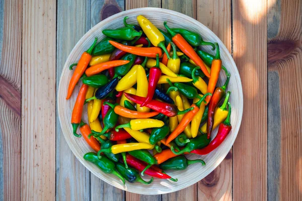 Gemengde kleuren hete paprika 's op houten bord — Stockfoto
