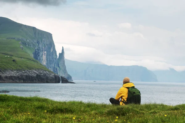 Touriste avec sac à dos en veste jaune regarde Witches Finger falaises — Photo