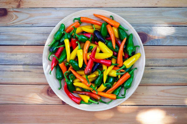 Gemengde kleuren hete paprika 's op houten bord — Stockfoto