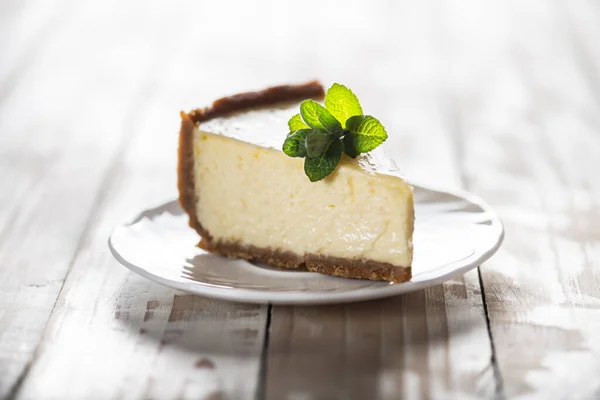 Slice of New York cheesecake with a sprig of mint — Stock Photo, Image
