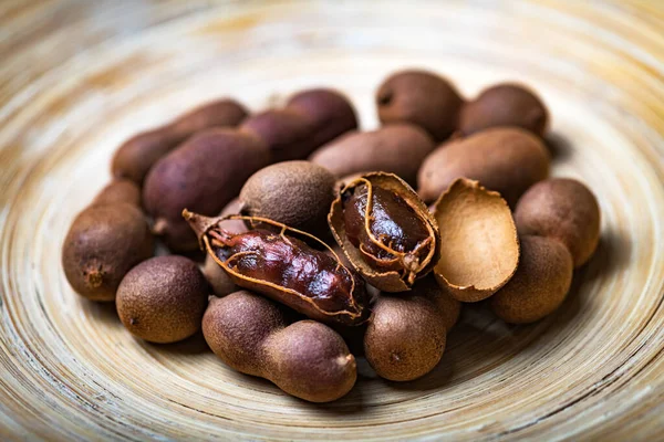 Frutos de tamarindo exóticos orgânicos secos em tigela de bambu — Fotografia de Stock