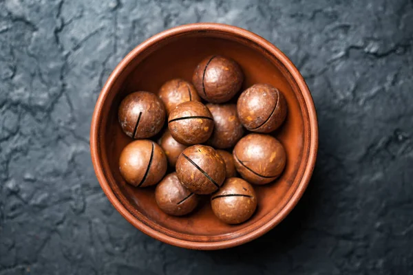 Suszone organiczne orzechy makadamia w pomarańczowej ceramicznej misce — Zdjęcie stockowe