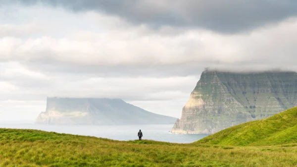 Turista solitario vicino a piccolo lago guarda le isole nebbiose nell'oceano Atlantico — Foto Stock