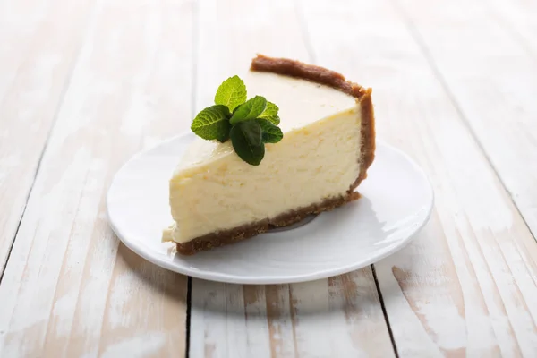 Slice of New York cheesecake with a sprig of mint — Stock Photo, Image