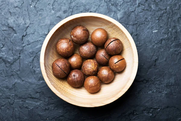 Nueces secas de macadamia orgánica en tazón de cerámica naranja —  Fotos de Stock