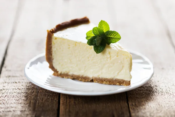 Slice of New York cheesecake with a sprig of mint — Stock Photo, Image