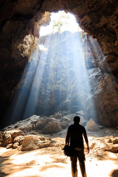 Prachtige zonnestraal met de man in een grot — Stockfoto