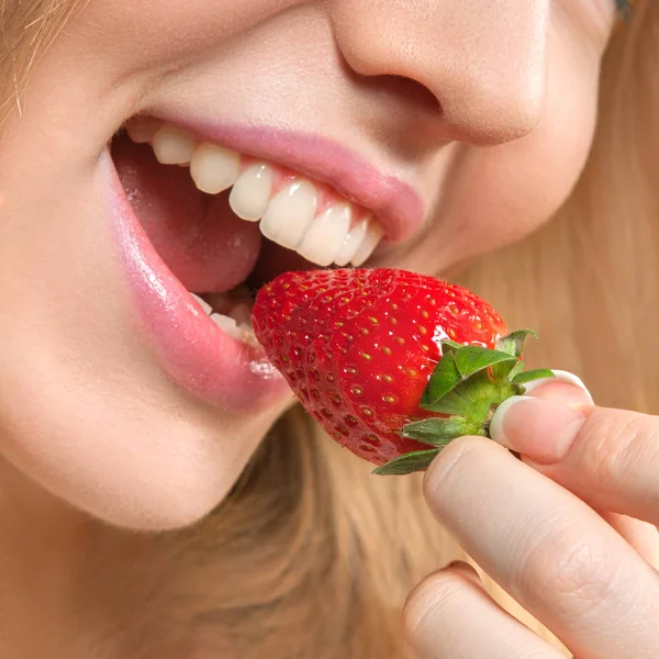美しい若い女性はイチゴを食べる — ストック写真