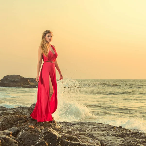 Жінка в довгій сукні перед морем — стокове фото