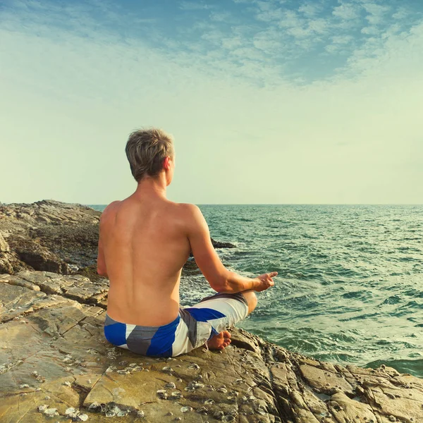 Man meditating in front of sea — Stock Photo, Image