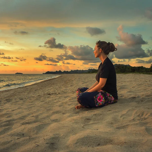 Vrouw mediterend op het strand — Stockfoto