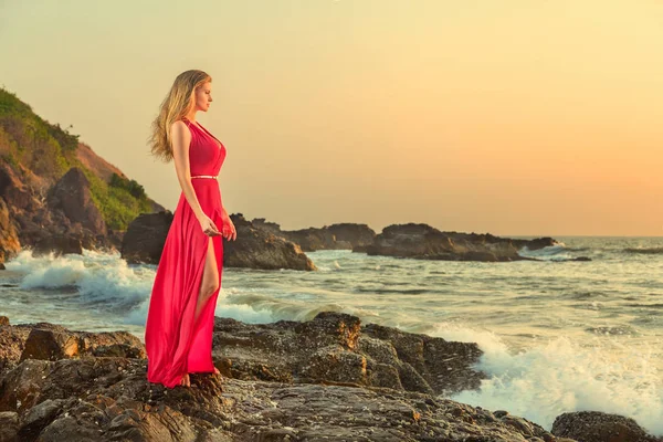 Kvinna i lång klänning framför havet — Stockfoto