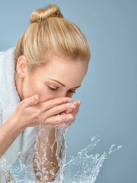 Jonge vrouw haar gezicht wassen — Stockfoto