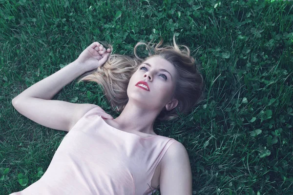 Junge Frau legt sich auf Gras — Stockfoto