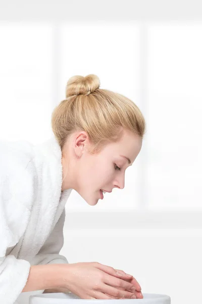 Молода жінка миє обличчя — стокове фото