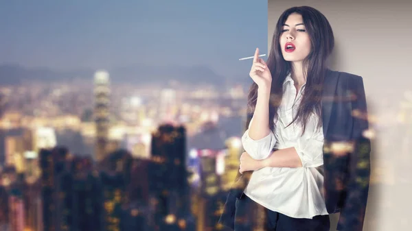 Mujer fumando en balcón en la ciudad de noche —  Fotos de Stock