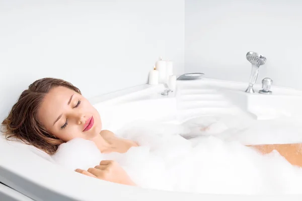 Young woman enjoying bathing in bathtub — Stock Photo, Image