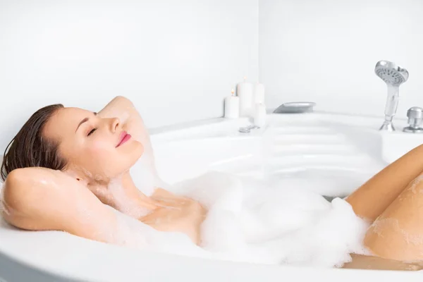 Mujer joven disfrutando bañándose en la bañera —  Fotos de Stock