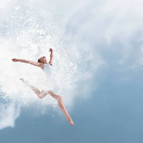 Mooie balletdanser springen met wolk van poeder — Stockfoto