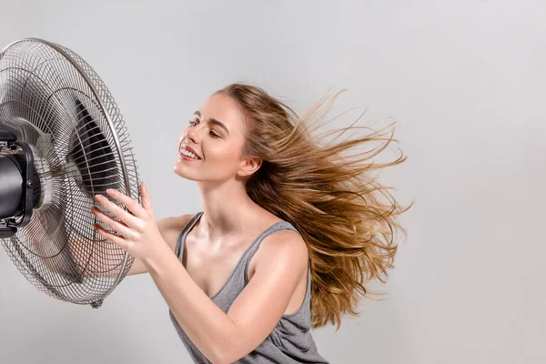 Молодая женщина с более крутым вентилятором — стоковое фото