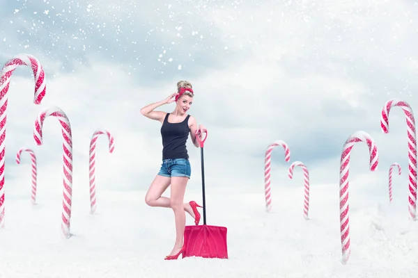 Pin-up girl med snöskyffel — Stockfoto