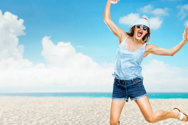 Glückliche junge Frau springt am Strand — Stockfoto
