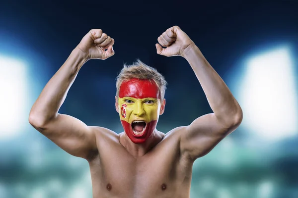 A Spanyolország lobogója alatt az arcán festett focirajongó — Stock Fotó