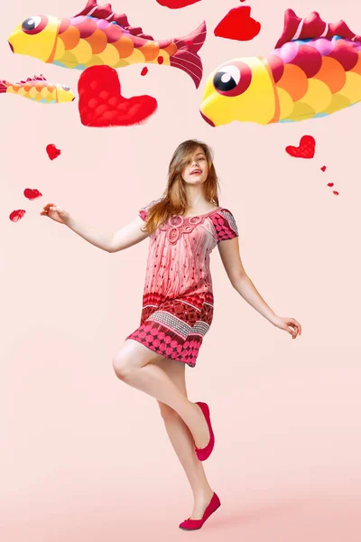 粉红色背景下放飞风筝的年轻女子肖像 — 图库照片