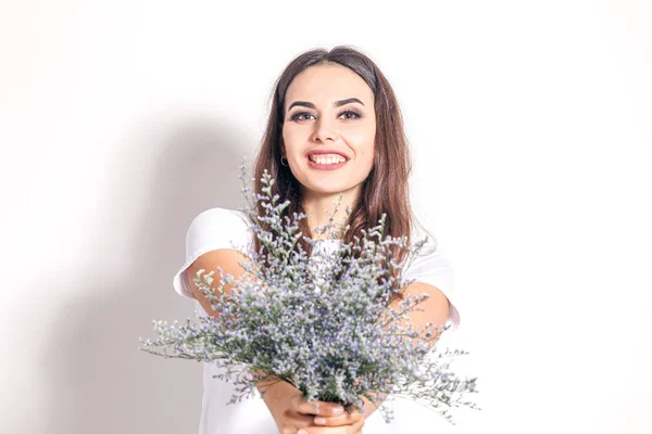 Junge schöne Frau mit wildem Blumenstrauß — Stockfoto