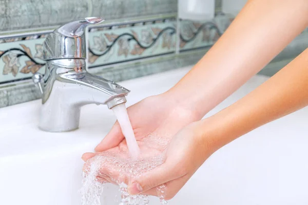 女性は手を洗うとコロナウイルスから肌をきれいにするためにバスルームに石鹸で顔 — ストック写真