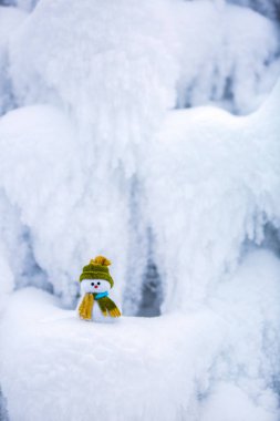 Kardan adam Noel Baba'nın Yardımcısı yeşil şapka duruyor.