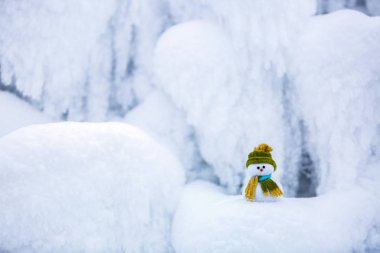 Kardan adam Noel Baba'nın Yardımcısı yeşil şapka duruyor.