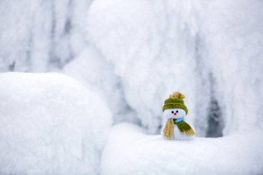 Kardan adam Noel Baba'nın Yardımcısı yeşil şapka duruyor.