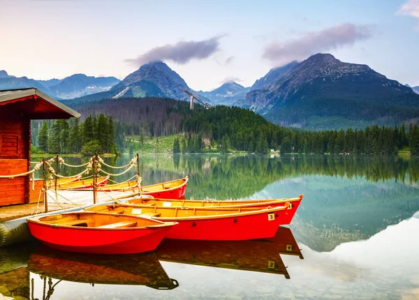 Red boats moored at wooden house on a lake. — Stock Photo, Image