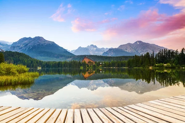 An old pier reveals views of the charmed lake, green mountains. — Stock Photo, Image