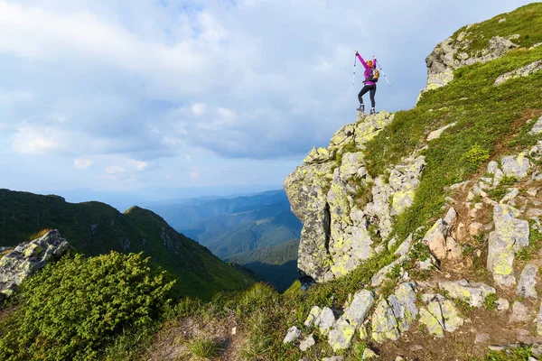 Menina desportiva na borda do precipício no alto das montanhas — Fotografia de Stock