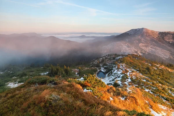 Le brouillard est au-dessus de la pelouse avec le lac . — Photo