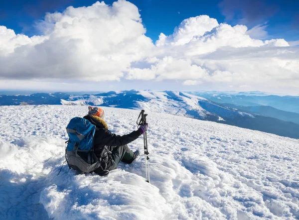 Dreaming girl is sitting on snowy hill at the high mountains. — Stock Photo, Image