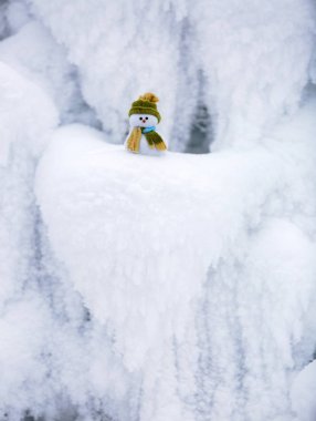 Kardan adam yeşil şapkalı eşarp ile sarılmış.